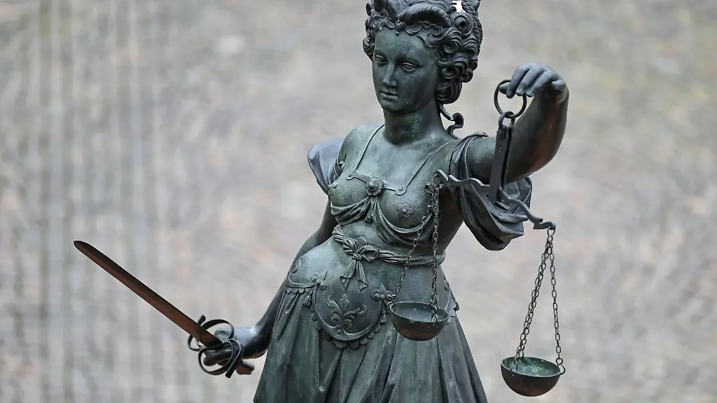 Eine-Statue-der-Justitia-haelt-eine-Waage-und-ein-Schwert-in-der-Hand