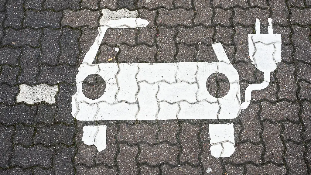 Ein-Symbol-fuer-E-Autos-ist-auf-einem-Parkplatz-zu-sehen
