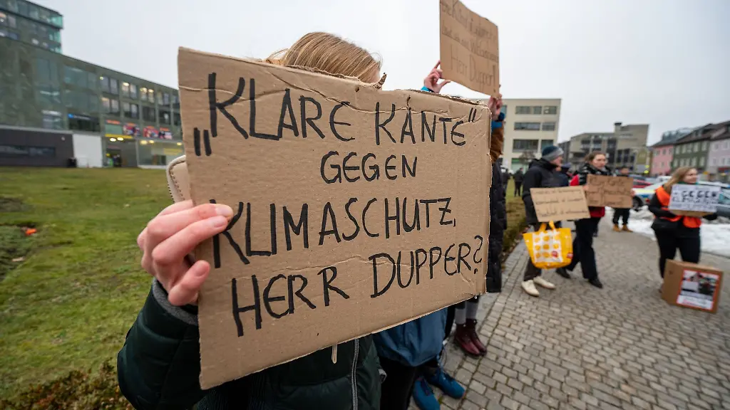 Klare-Kante-gegen-Klimaschutz-Herr-Dupper-steht-auf-dem-Schild-eines-Demonstranten-am-Rande-einer-Aktion-von-Aktivisten-der-Klimaschutzbewegung-Letzten-Generation-in-der-Innenstadt