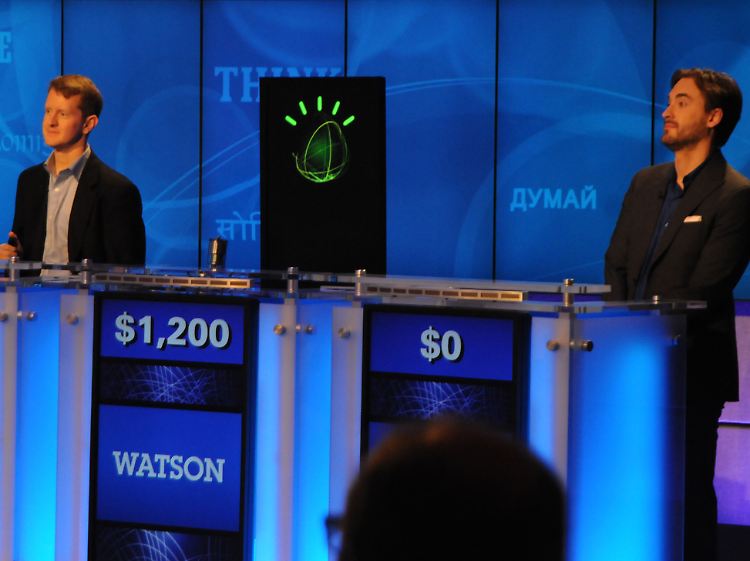 Die menschlichen Herausforderer Ken Jennings und Brad Buttler links und rechts von "Watson".