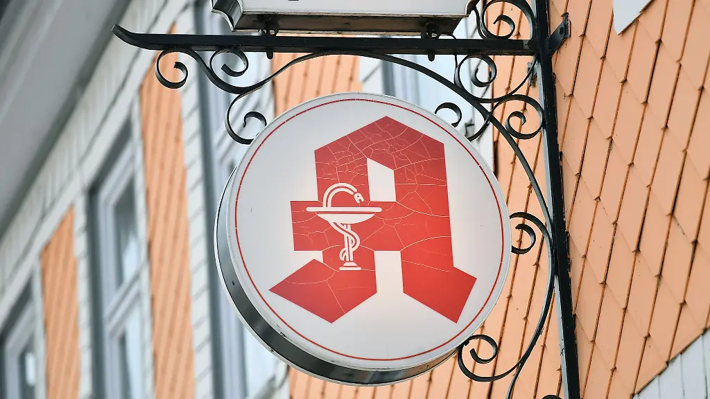 Das-Apothekenzeichen-an-der-Hausfassade-ueber-dem-Eingang-einer-Apotheke-eines-kleinen-Ortes