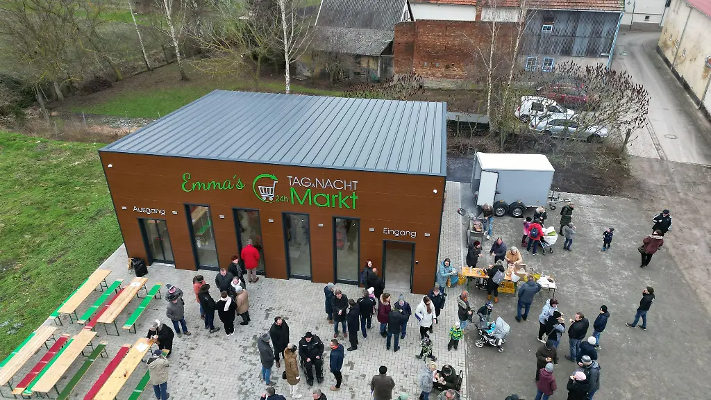 Besucher-stehen-bei-der-Eroeffnung-eines-24-Stunden-Dorfladens-vor-dem-24-Stunden-Markt