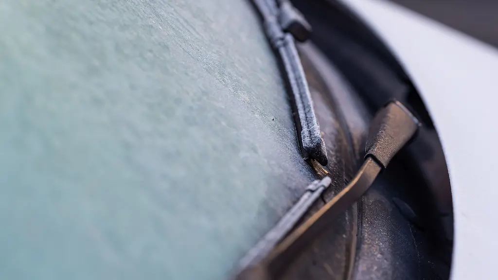 Eine-Eisschicht-liegt-auf-der-Windschutzscheibe-von-einem-Auto