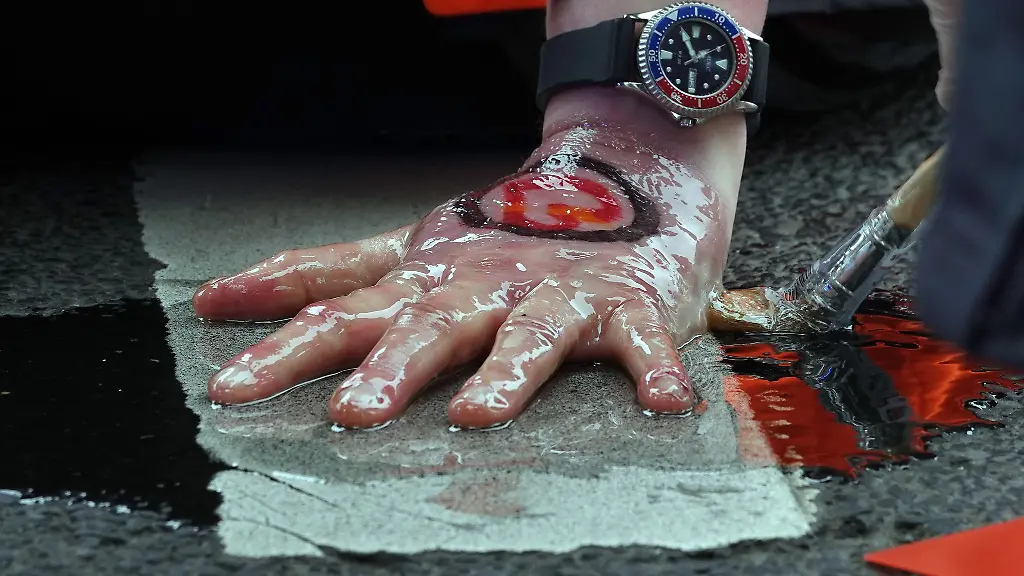 Polizisten-loesen-die-festgeklebte-Hand-eines-Aktivisten-der-Umweltgruppe-Letzte-Generation-von-der-Fahrbahn