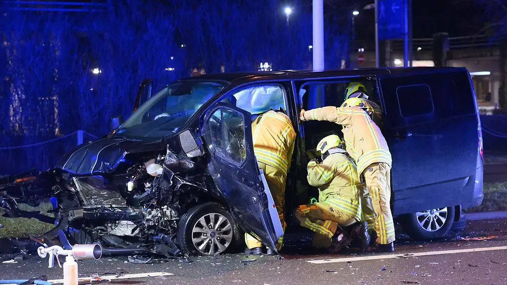 Einsatzkraefte-der-Feuerwehr-Hannover-stehen-an-einem-verunfallten-Kleinbus