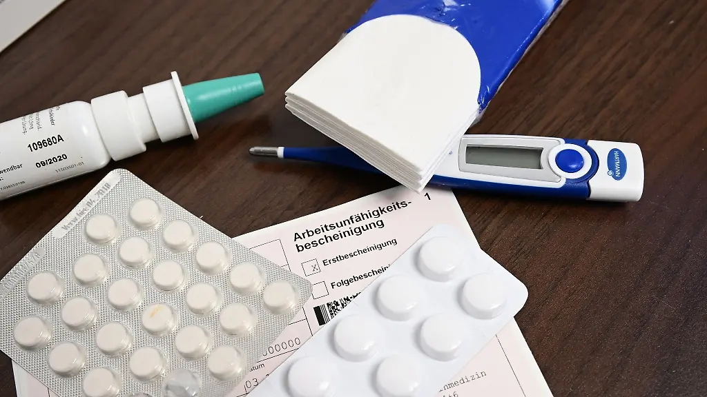 Ein-Fieberthermometer-Medikamente-und-eine-Krankmeldung-liegen-auf-einem-Nachttisch