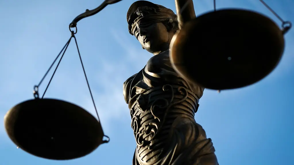Eine-Bronzefigur-stellt-die-Justitia-mit-Waage-in-der-Hand-dar