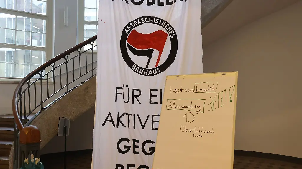 Plakate-zur-Besetzung-haengen-am-Haupteingang-der-Bauhaus-Universitaet-Die-Aktivisten-wollen-so-einen-Raum-fuer-die-Auseinandersetzung-mit-den-gegenwaertigen-Krisen-ihren-Ursachen-und-Wegen-zu-deren-Ueberwindung-schaffen