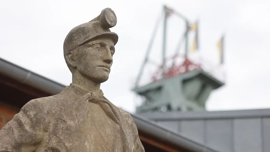 Eine-Bergamannsfigur-steht-vor-dem-Eingang-im-Besucherbergwerk-Roehrigschacht-in-Wettelrode
