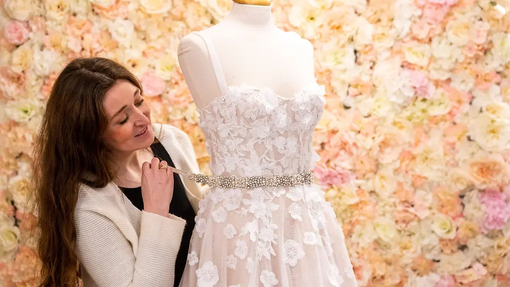 Stefanie-von-Harbou-steht-in-ihrem-Geschaeft-Brautmoden-Happy-im-Stadtteil-Glockenbach-neben-einem-Brautkleid