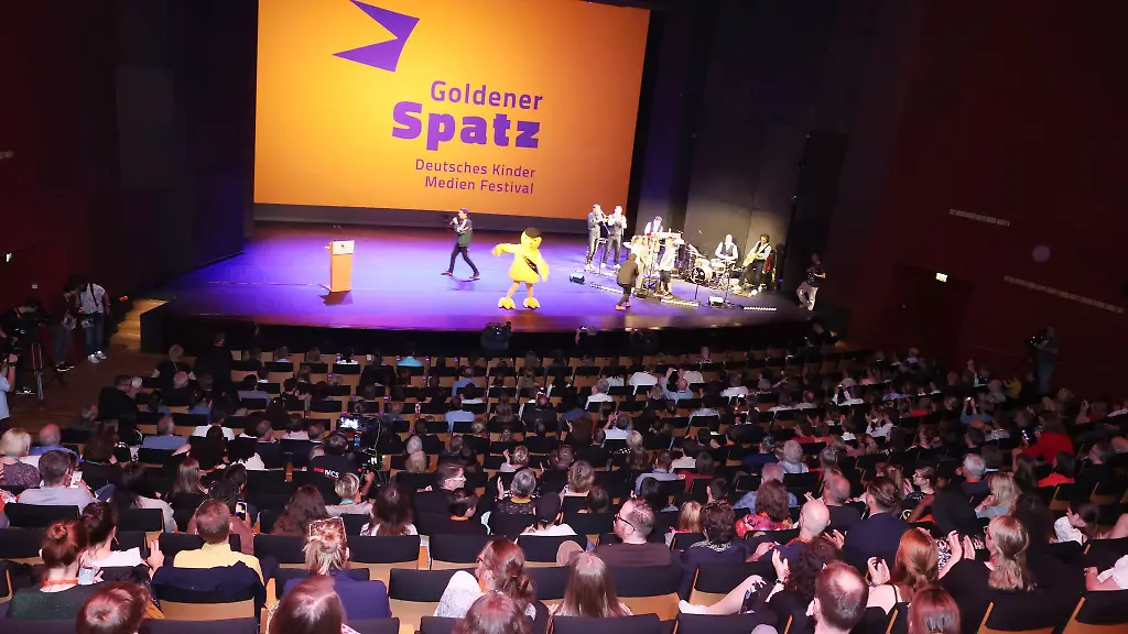 Preistraeger-Jury-und-Mitwirkende-stehen-auf-der-Buehne-bei-der-Preisverleihung-Goldener-Spatz