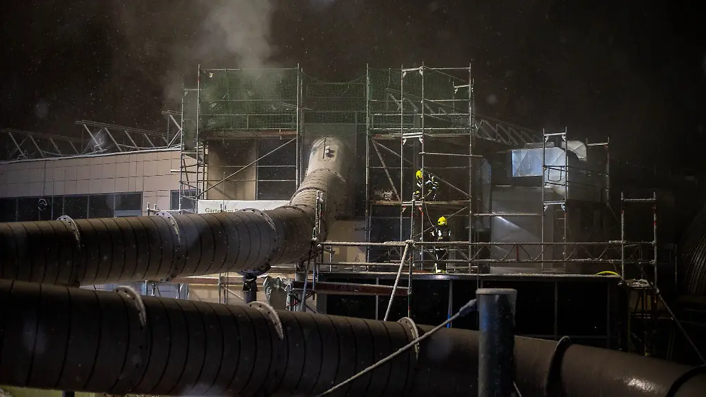 Einsatzkraefte-der-Feuerwehr-loeschen-den-Brand-in-einem-Schwimmbad