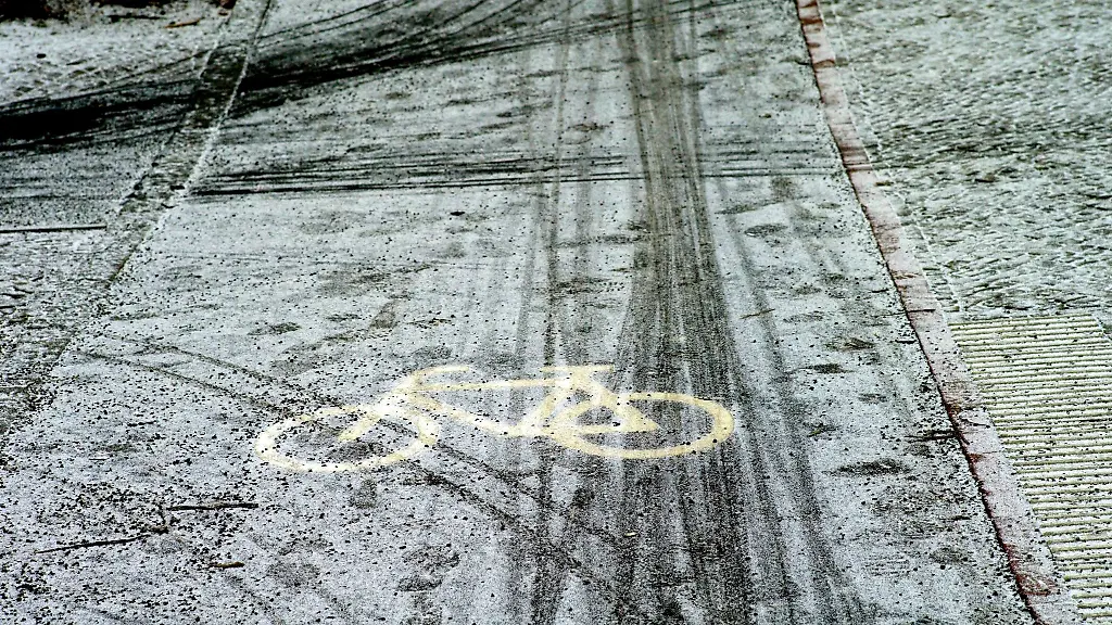 Fahrraeder-haben-auf-einem-Radweg-Spuren-im-Schnee-hinterlassen