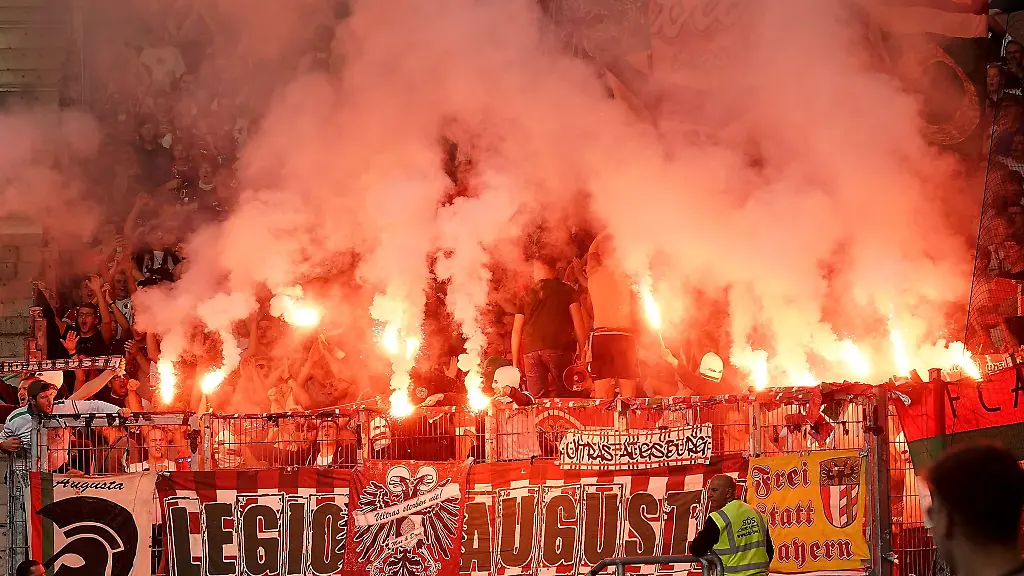 Die-Augsburger-Fans-zuenden-Bangalische-Feuer-im-Block
