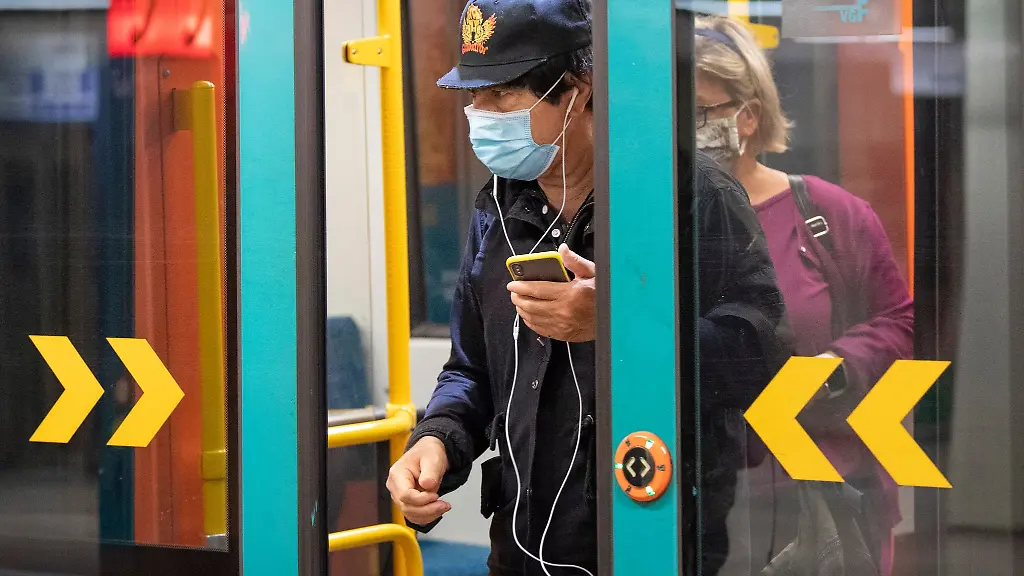 Durch-das-Tragen-von-Mund-Nase-Bedeckungen-schuetzen-sich-Fahrgaeste-in-einer-Bahn-vor-dem-Coronavirus