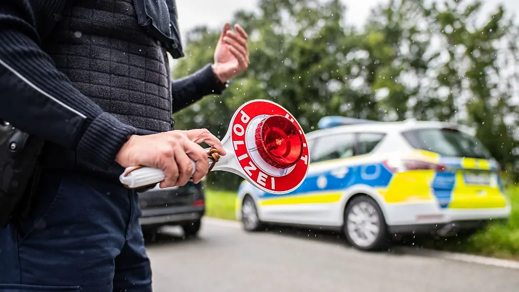 Eine-Polizistin-haelt-eine-Winkerkelle-in-der-Hand