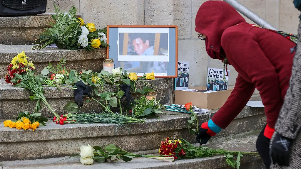 Eine-Frau-legt-eine-Rose-zum-Gedenken-an-Oury-Jalloh-auf-die-Stufen-des-Polizeireviers