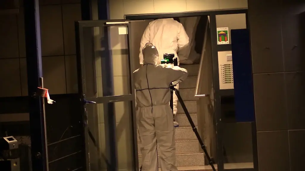 Mitarbeiter-der-Spurensicherung-gehen-in-das-Treppenhaus-des-Tathauses