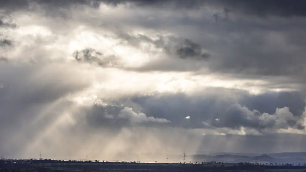 Sonnenstrahlen-fallen-durch-Loecher-in-den-Regenwolken-und-sorgen-fuer-einen-dramatischen-Himmel