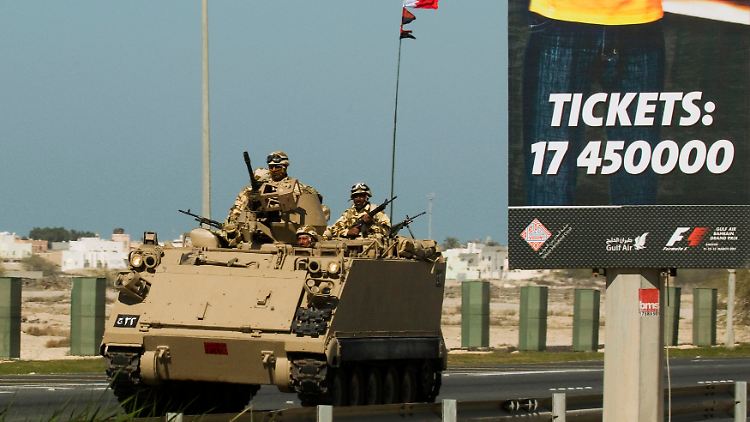 Ein Panzer passiert in Bahrain ein Werbeplakat für den Formel-1-Grand-Prix Mitte März. Die Austragung des Rennens wird immer unwahrscheinlicher.