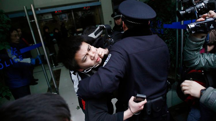Polizisten in Shanghai nehmen einen Demonstrant fest.
