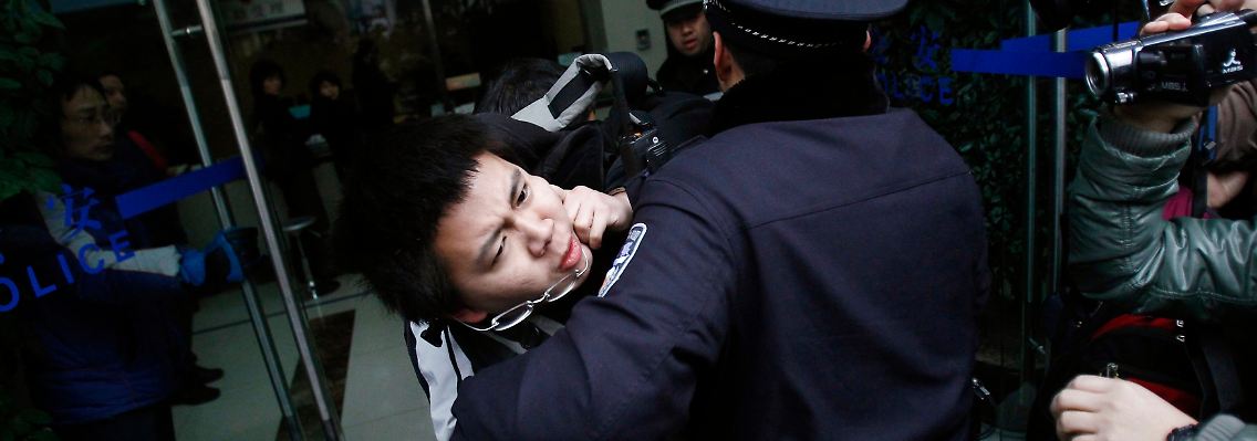 Polizisten in Shanghai nehmen einen Demonstrant fest.