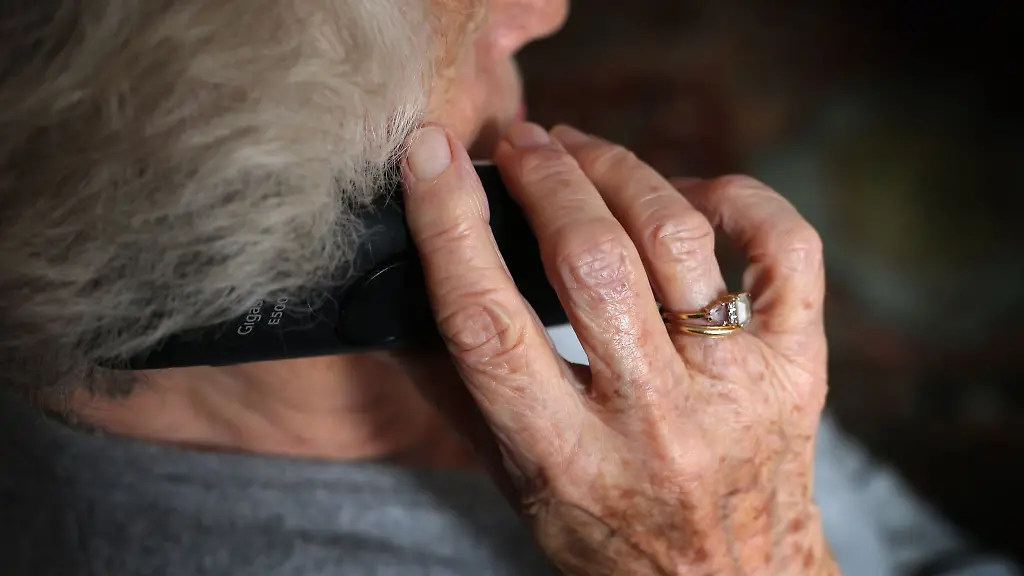 Eine-aeltere-Frau-telefoniert-mit-einem-schnurlosen-Festnetztelefon