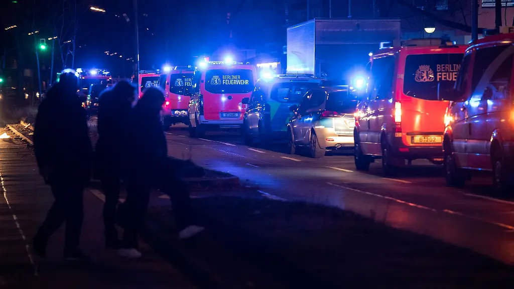 Einsatzfahrzeuge-der-Feuerwehr-stehen-in-der-Silvesternacht-auf-einer-Strasse