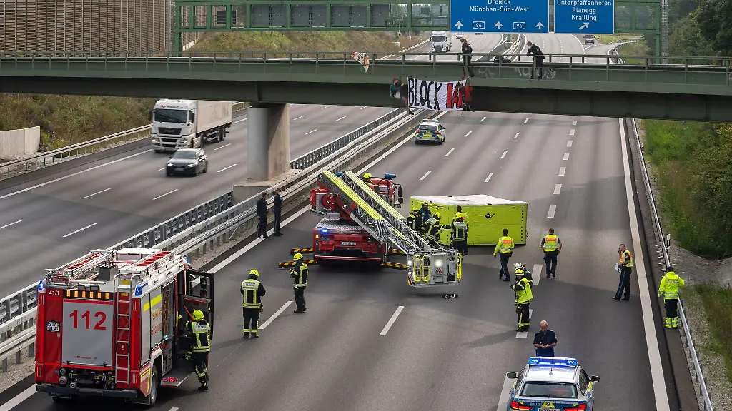Aktivisten-nehmen-an-einer-Banneraktion-an-einer-Bruecke-ueber-der-Autobahn-A96-bei-Germering-teil