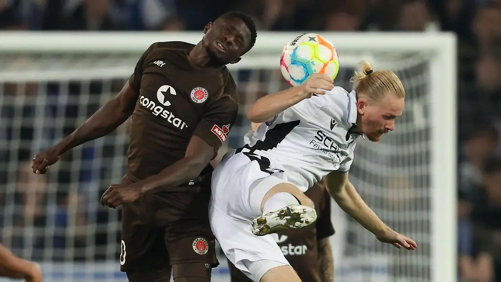 Bielefelds-Jomaine-Consbruch-r-im-Kampf-um-den-Ball-mit-St-Paulis-Afeez-Aremu-l