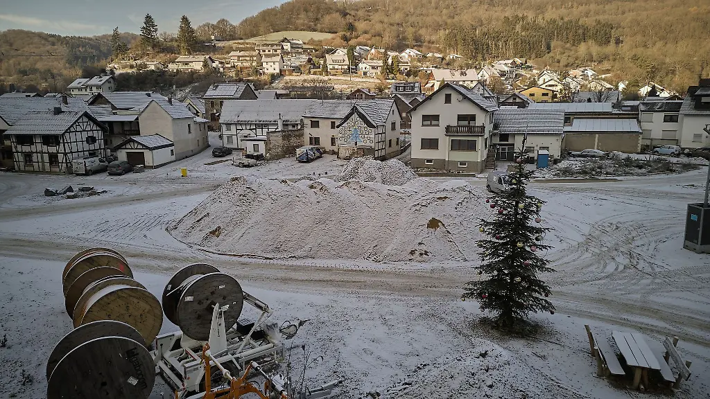 Ein-Weihnachtsbaum-steht-auf-einer-Baustelle-in-der-von-der-Hochwasserkatastrophe-stark-betroffenen-Ortschaft-Schuld