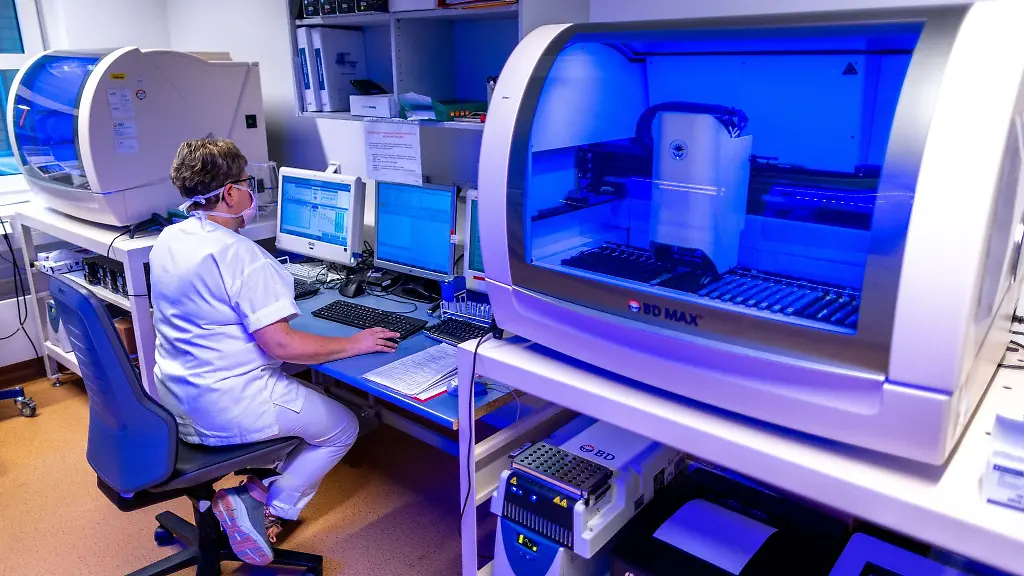 Eine-Medizintechnische-Assistentin-prueft-die-Ergebnisse-von-Proben-in-einem-PCR-Labor