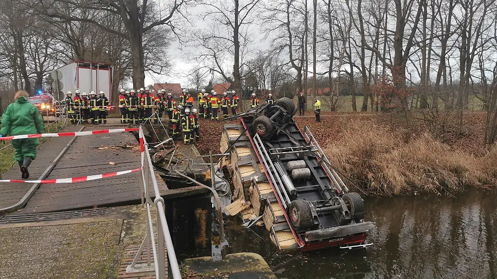 Ein-mit-Gefluegel-beladenes-Lastwagengespann-faellt-in-einen-Kanal
