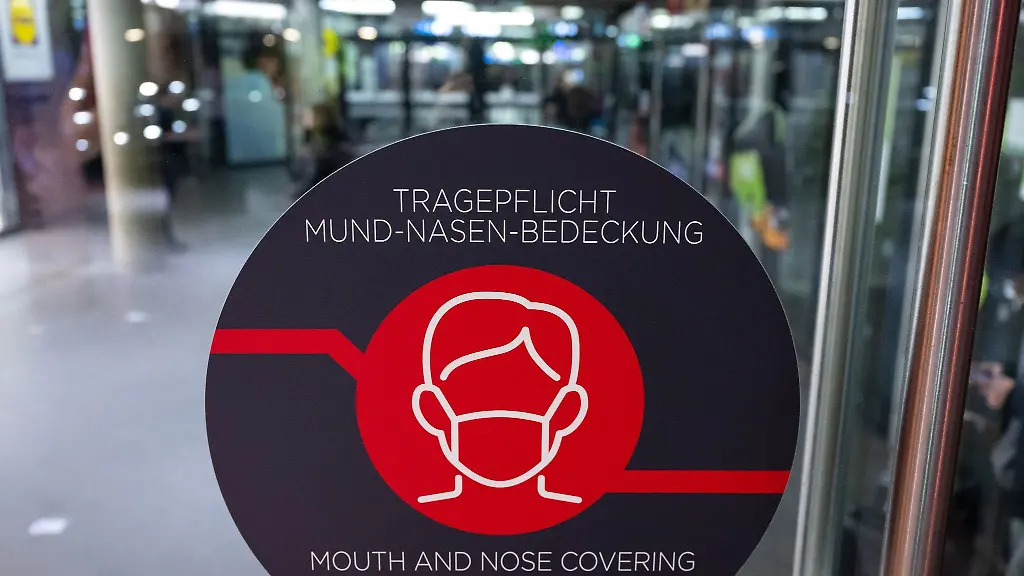 Ein-Schild-mit-der-Aufschrift-Tragepflicht-Mund-Nasen-Bedeckung-ist-an-einer-Tuer-zu-sehen