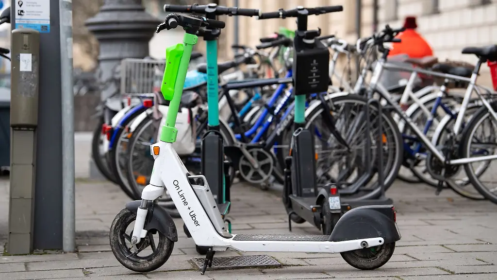 E-Scooter-stehen-in-der-Innenstadt-auf-einem-Gehweg