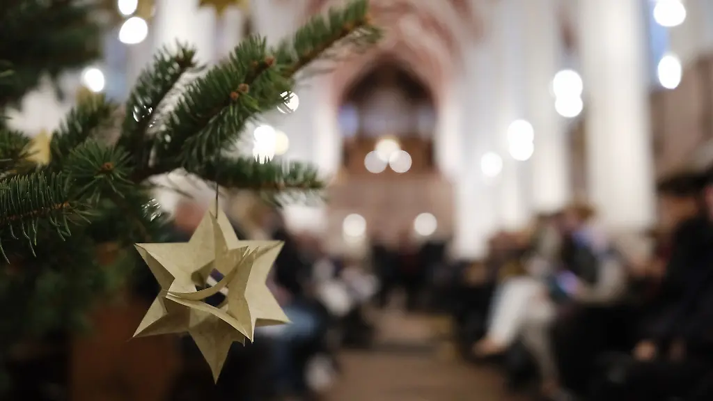 Ein-Papierstern-haengt-an-den-Zweigen-eines-geschmueckten-Weihnachtsbaumes