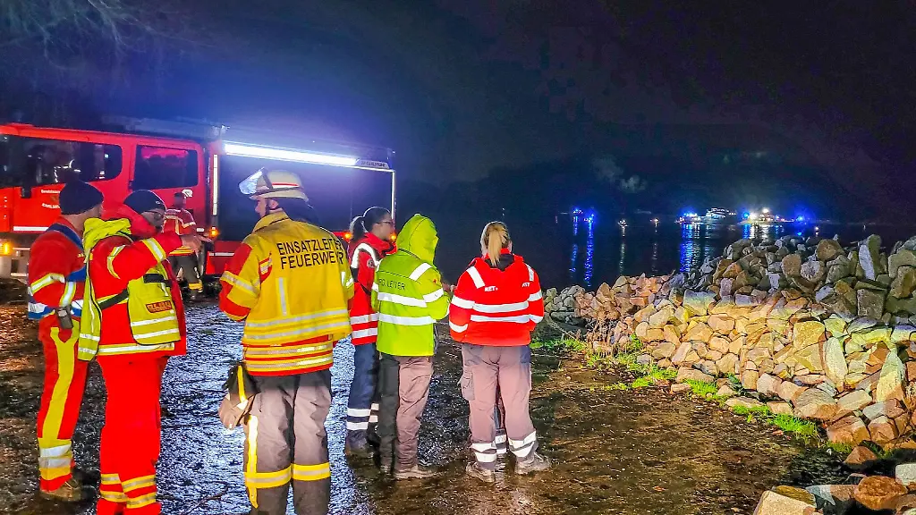 Feuerwehrleute-stehen-am-Ufer-des-Rheins