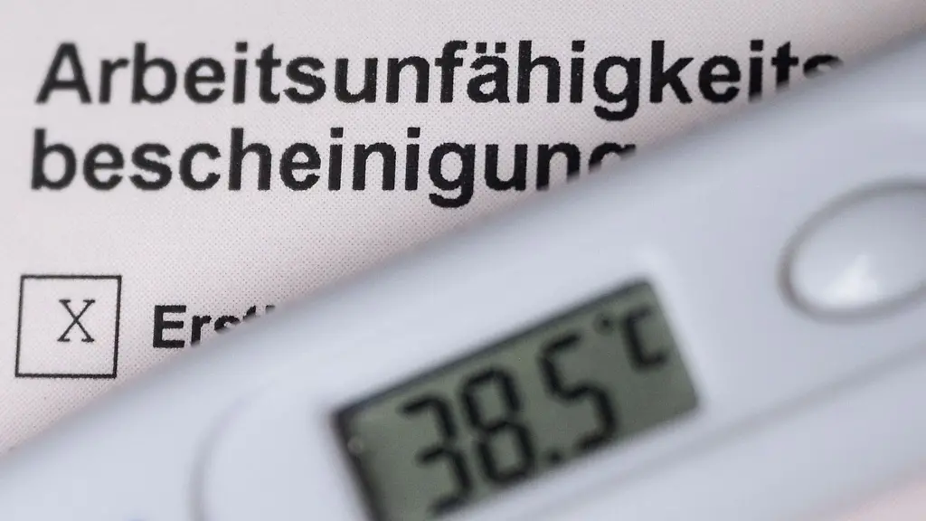 Ein-Fieberthermometer-liegt-auf-einer-Arbeitsunfaehigkeitsbescheinigung