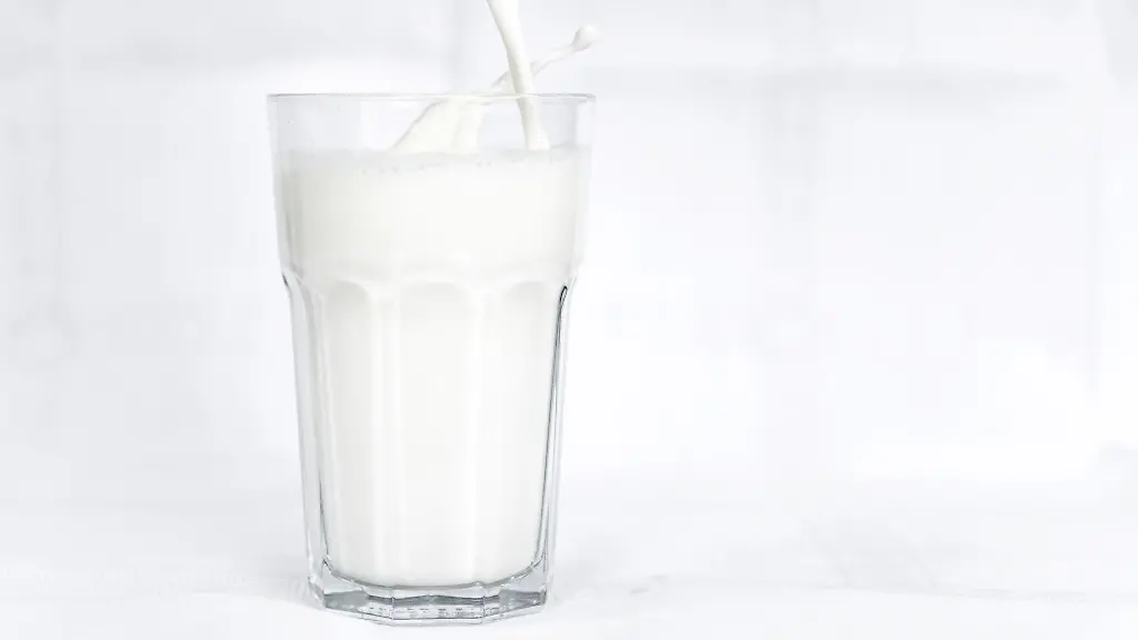 Kuhmilch-wird-in-ein-Glas-geschuettet