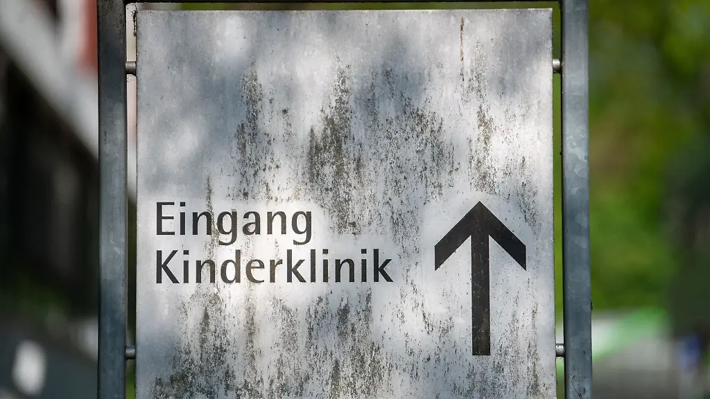 Ein-verwittertes-Schild-weist-zum-Eingang-der-Kinderklinik