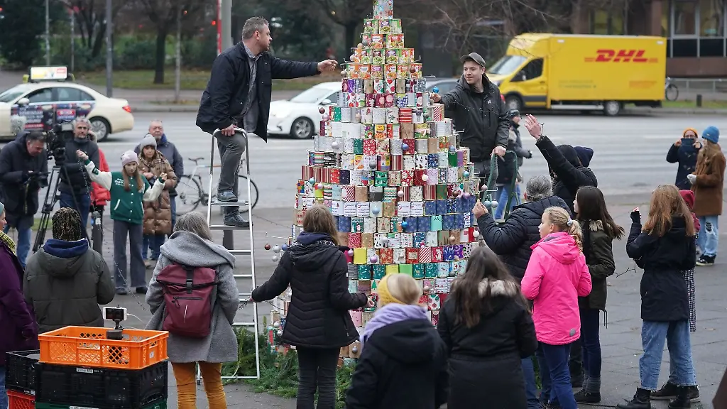 Helfende-schmuecken-den-groessten-Weihnachtsbaum-aus-Konservendosen-vor-dem-Hamburger-Michel