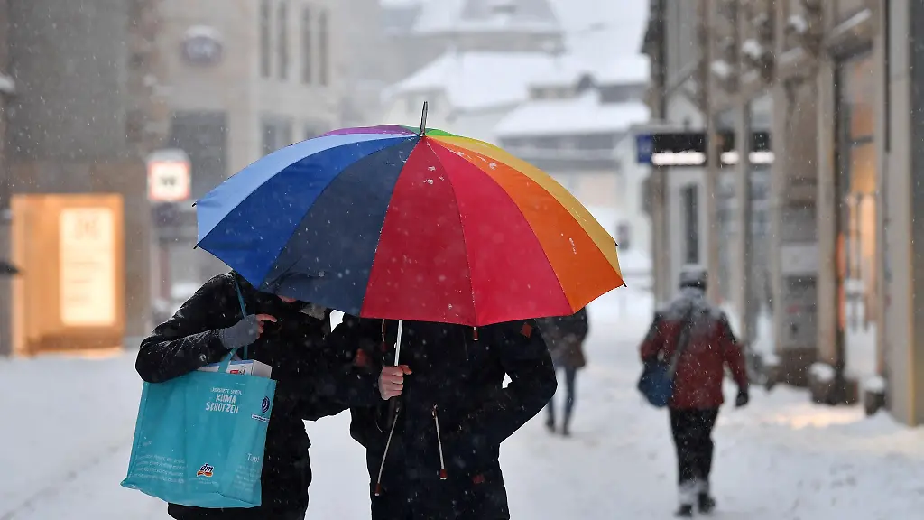 Fussgaenger-laufen-mit-einem-Schirm-durch-die-Innenstadt