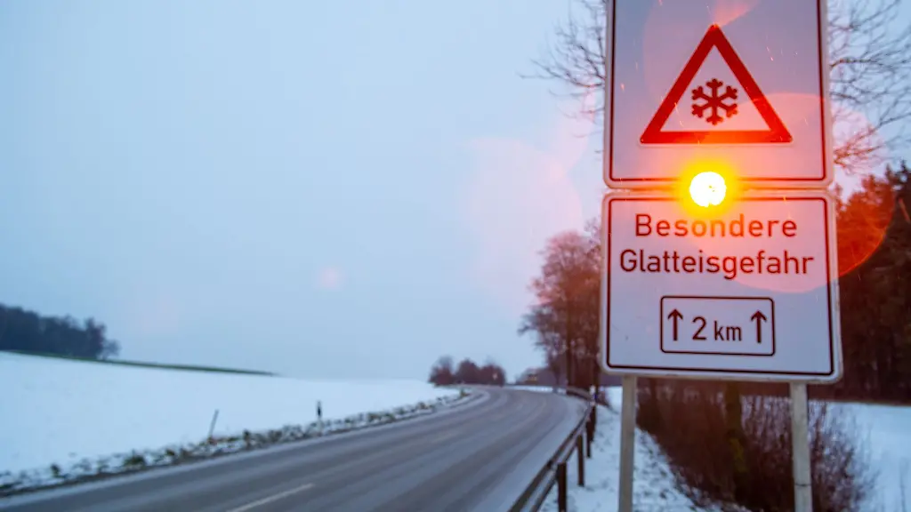 Ein-Strassenschild-warnt-mit-einer-Blinkleuchte-vor-Glatteis