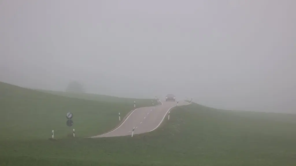 Ein-Auto-faehrt-durch-die-nebelverhangene-Landschaft