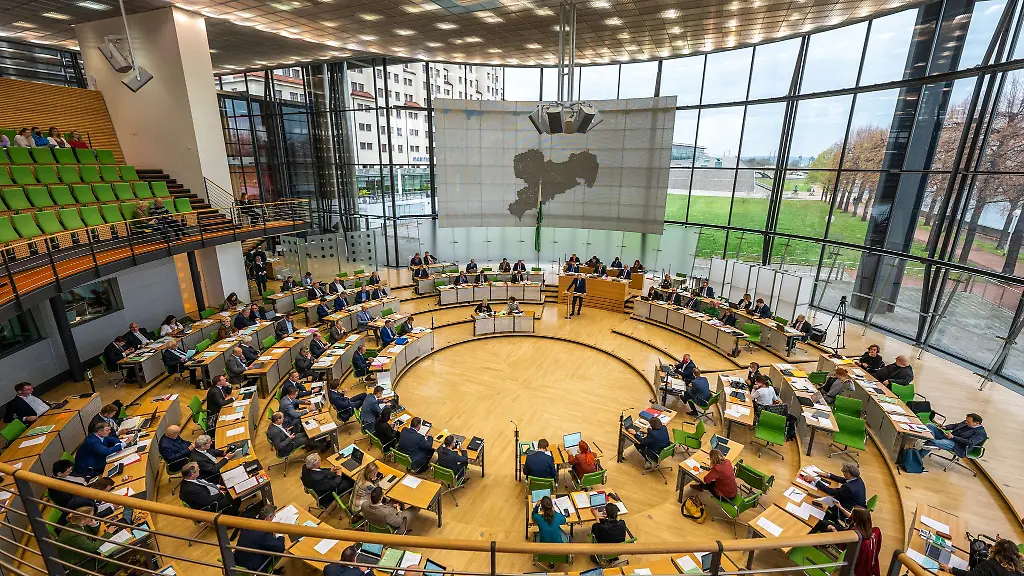 Abgeordnete-sitzen-bei-einer-Sitzung-des-Saechsischen-Landtags-im-Plenum-auf-ihren-Plaetzen