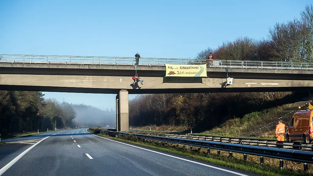 Umweltaktivisten-seilen-sich-bei-Schleswig-an-einer-Bruecke-ueber-der-Autobahn-7-A7-ab