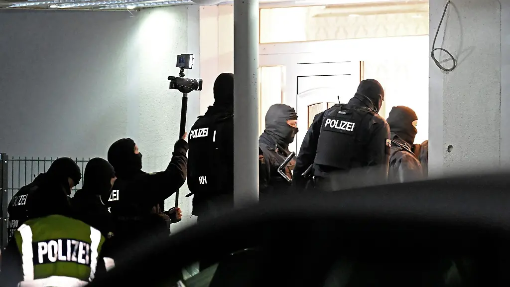 Polizisten-dringen-im-Rahmen-einer-gross-angelegten-Razzia-in-ein-Haus-ein