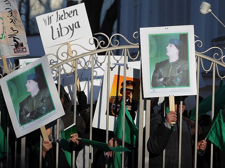 Unterstützer des libyschen Staatschefs Muammar al-Gaddafi stehen auf dem Gelände der libyschen Botschaft in Berlin.