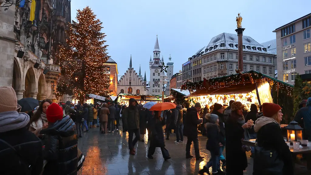 Menschen-gehen-ueber-den-festlich-geschmueckten-Christkindlmarkt-auf-dem-Marienplatz