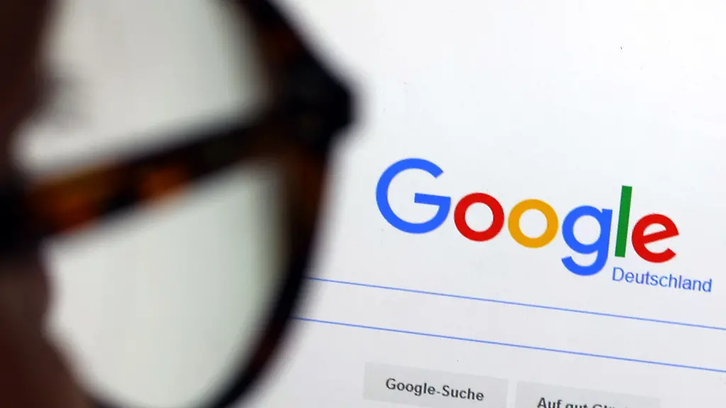 Die-Seite-der-Suchmaschine-von-Google-ist-hinter-einer-Frau-mit-Brille-zu-sehen